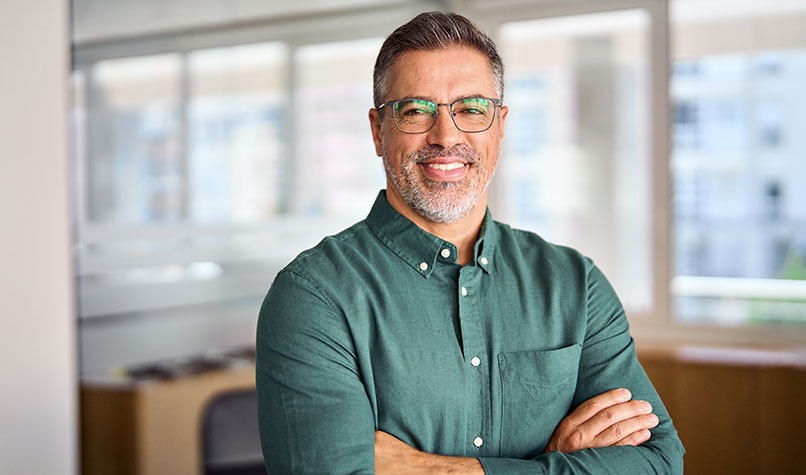 Businessman in a green shirt folding his arms across his chest