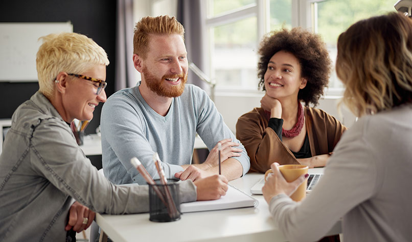 A team of office colleagues laughing around a table