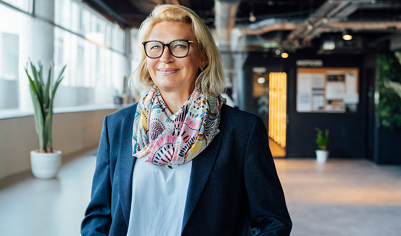 Smiling woman standing in an open plan office