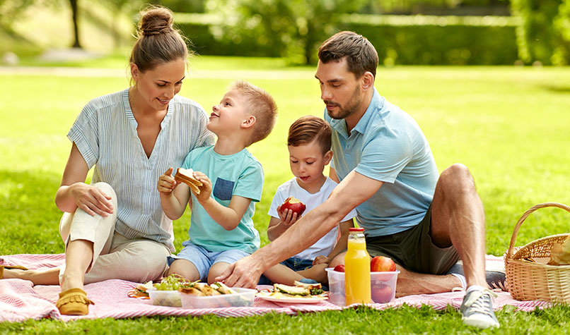 Two parents and two children having a picnic in a park