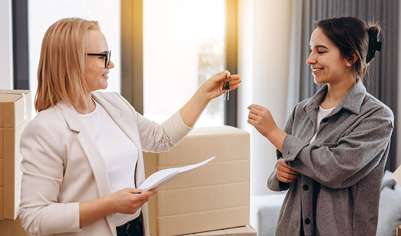 Female landlord handing keys over to a female tenant.