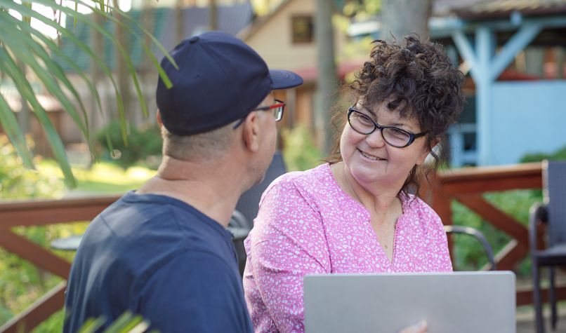 A man and woman chatting over a laptop
