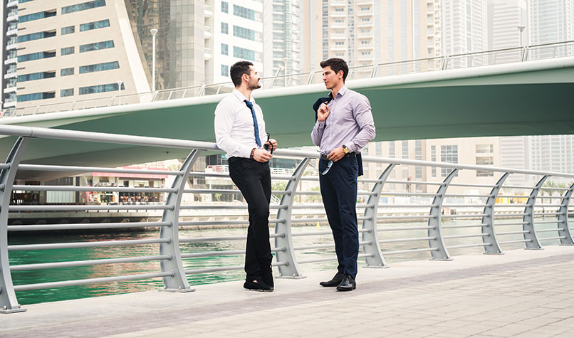 Two businessmen talking to each other at Dubai Marina